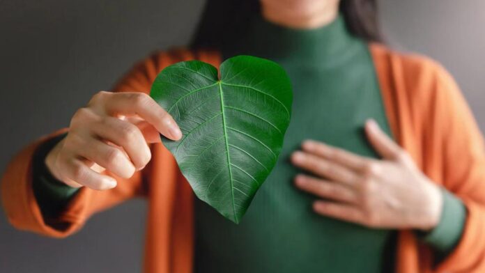 A woman holding a leaf showcasing sustainable practices importance for your e-commerce business